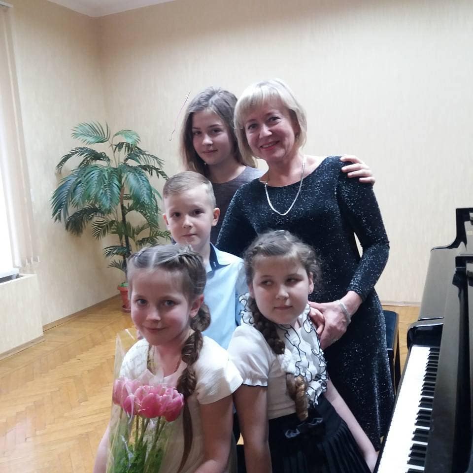 Larysa with students by the piano